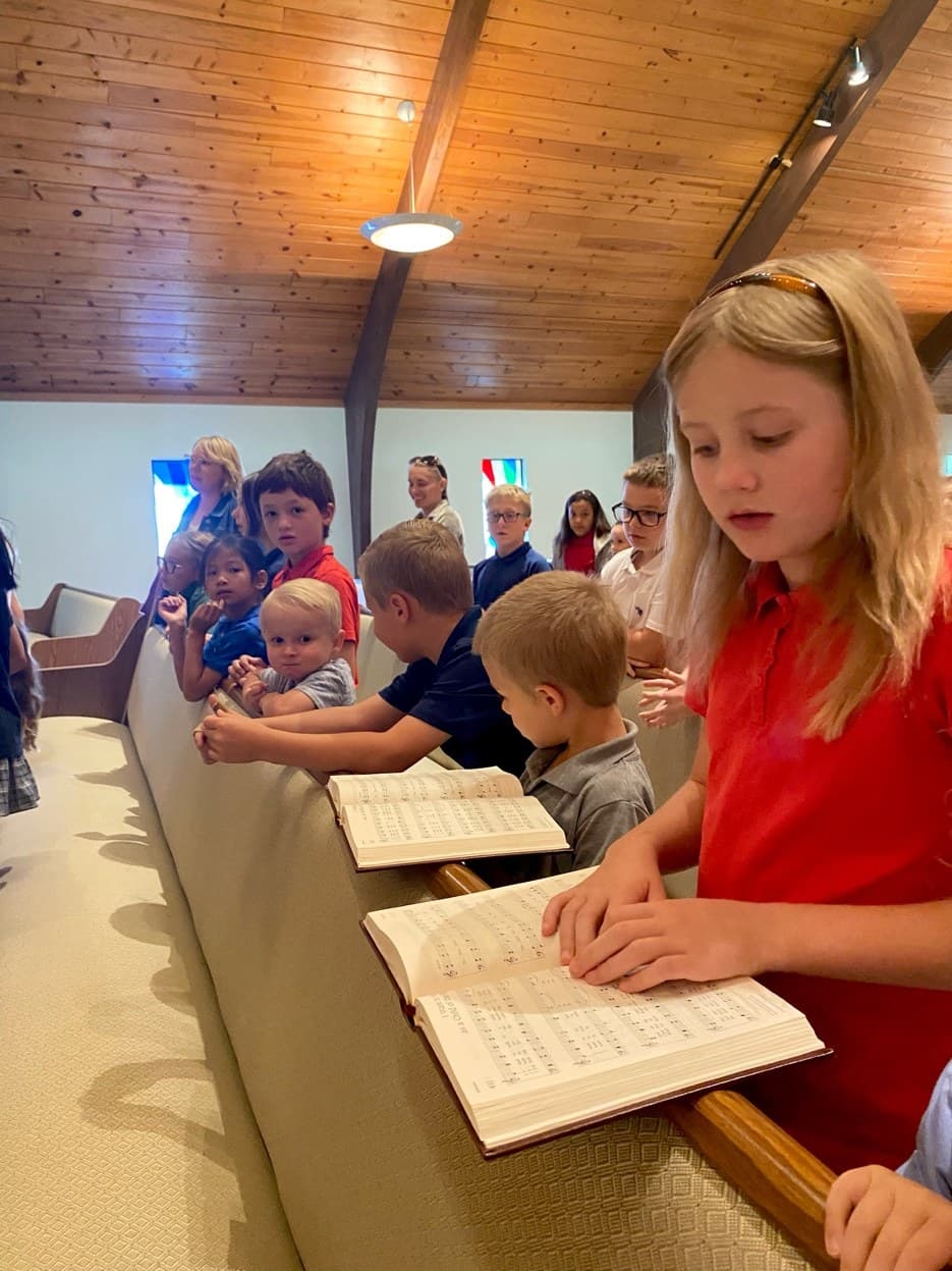 Children gathered with hymnals during worship