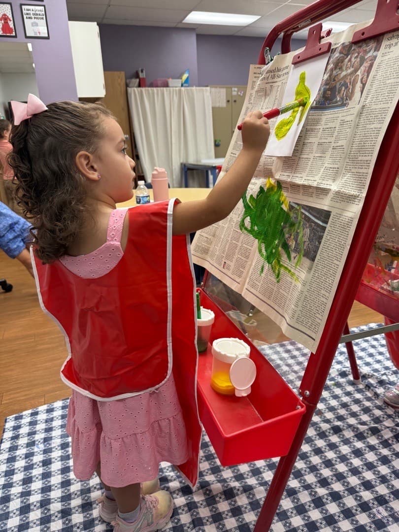 Preschooler painting at the easel
