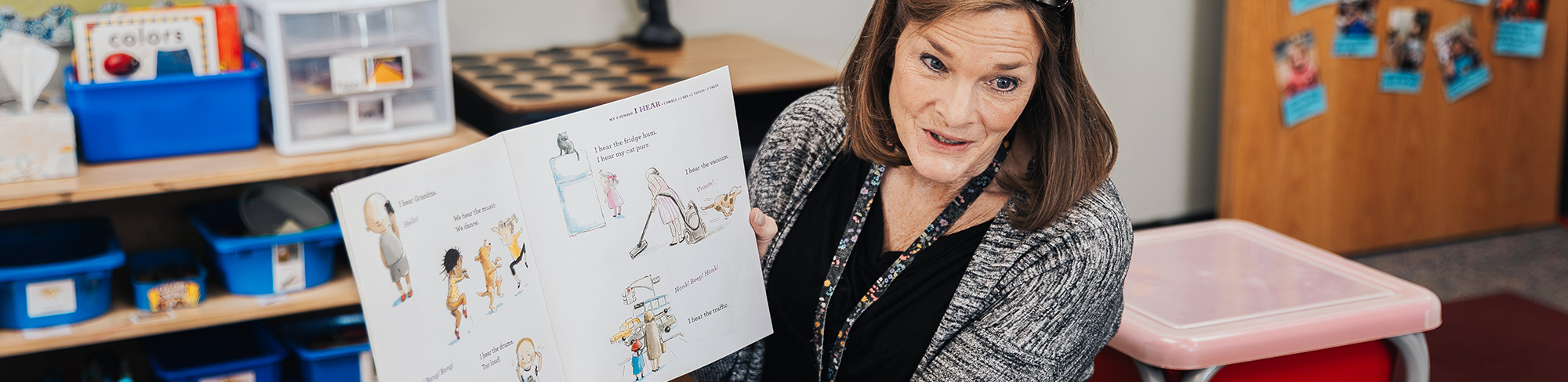 Pretty woman reading a book to students