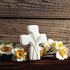 cross and flowers on wooden background