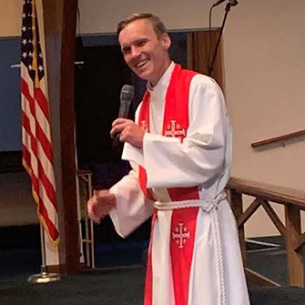 Pastor Joshua holding microphone