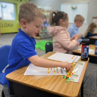 Boy working on a math worksheet at his desk