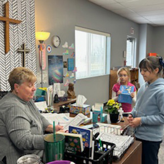 Students talking to teacher at her desk
